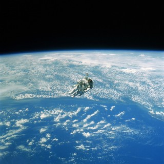 astronaut hanging above the earth ipad wallpaper